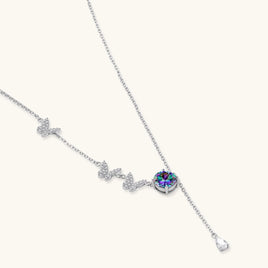 Delicate sterling silver necklace with crystal-set butterfly charms and rainbow moissanite pendant on white background.