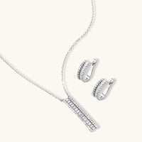 Linear baguette zirconia pendant necklace and matching curved huggie earrings | Olaty