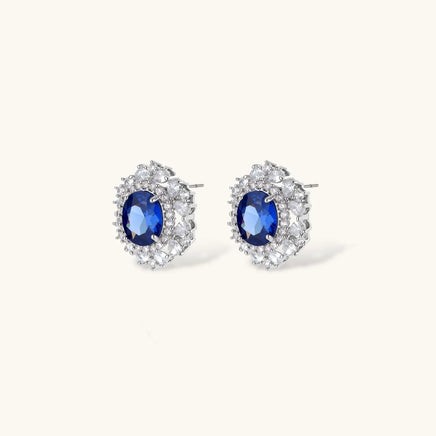 Sapphire blue oval halo stud earrings surrounded by clear zirconia stones | Olaty