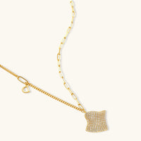 Wave pendant necklace and matching stud earrings arranged on cream background | Olaty