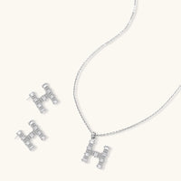 H initial Zirconia necklace and matching stud earrings arranged together | Olaty