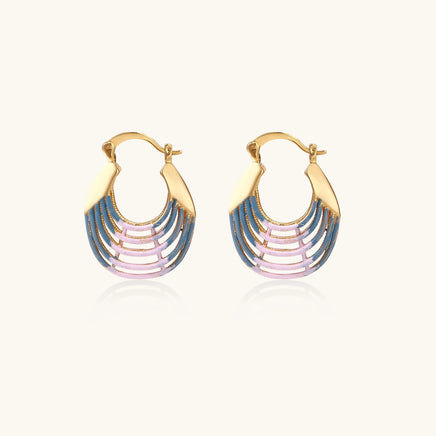 Gold hoop earrings with gradient blue-to-pink enamel in ribbed fan design on beige background