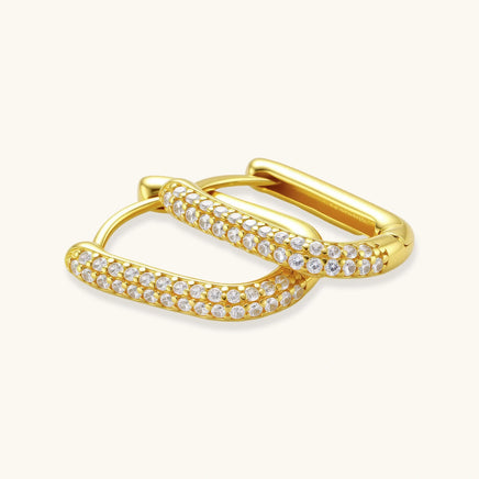 Open gold huggie hoop earrings showing pavé crystal setting and hinged closure | Olaty