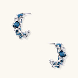 Blue denim sculptural wave hoop earrings with polished silver-tone organic frames | Olaty