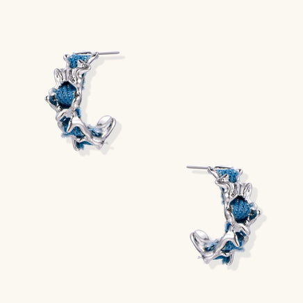 Blue denim sculptural wave hoop earrings with polished silver-tone organic frames | Olaty