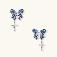 Royal blue denim butterfly drop earrings with silver-tone sculptural wings, pearl centers and dangling cross charms | Olaty