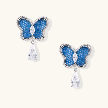 Electric blue denim butterfly drop earrings with silver-tone frames and sparkling clear zirconia teardrop pendants | Olaty