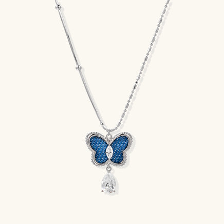 Blue denim butterfly pendant necklace with zirconia center and dangling teardrop stone | Olaty