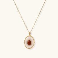 Front view of oval amber cameo pendant necklace with mother-of-pearl surround and sparkling stone accents | Olaty