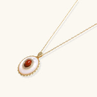 Angled view of amber cameo pendant necklace with oval mother-of-pearl detail and sparkling halo | Olaty
