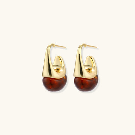 Amber resin drop earrings with polished sculptural gold curves shown at an angle | Olaty
