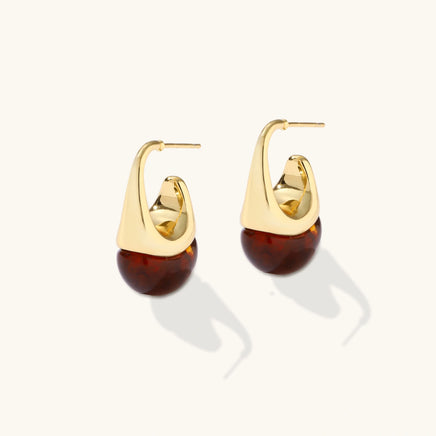 Sculptural amber resin drop earrings with polished gold curves and visible post closures | Olaty