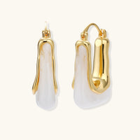 Liquid curve white resin hoop earrings with sculptural gold-tone frames, front and side view | Olaty