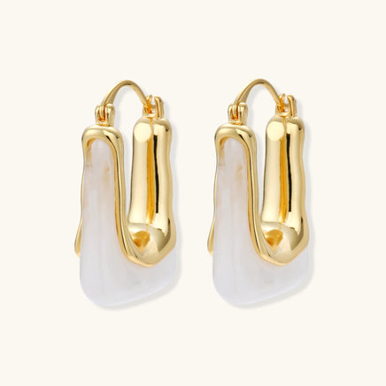 Liquid curve white resin hoop earrings with polished gold-tone frames, angled pair view | Olaty