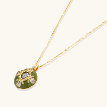 2. Emerald green enamel pendant necklace with oval center stone and zirconia details, angled view | Olaty