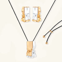 Two-tone sculptural jewelry set with gold and silver abstract earrings and black cord pendant necklace | Olaty
