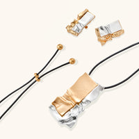 Gold and silver sculptural pendant necklace with matching abstract statement earrings and adjustable black cord | Olaty