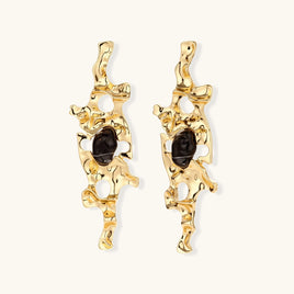Gold-tone abstract statement earrings with organic cutouts and dark resin center accents | Olaty