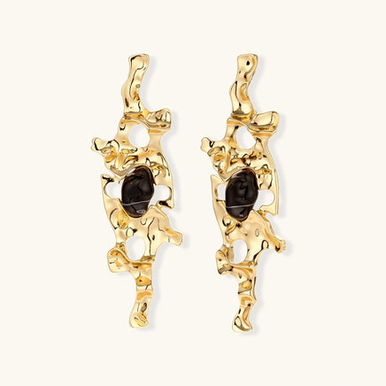 Gold-tone abstract statement earrings with organic cutouts and dark resin center accents | Olaty