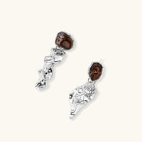 Angled view of fluid silver-tone drop earrings with irregular brown resin stones and sculptural forms | Olaty