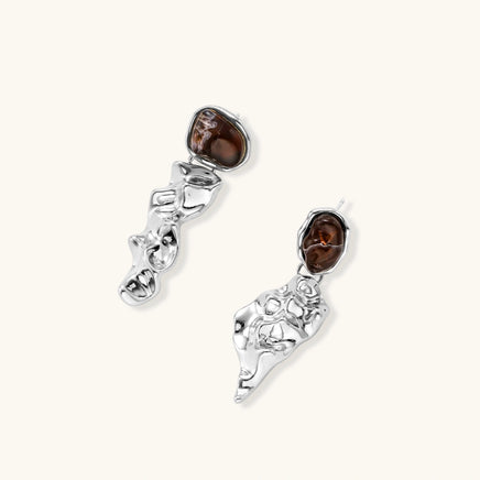 Angled view of fluid silver-tone drop earrings with irregular brown resin stones and sculptural forms | Olaty