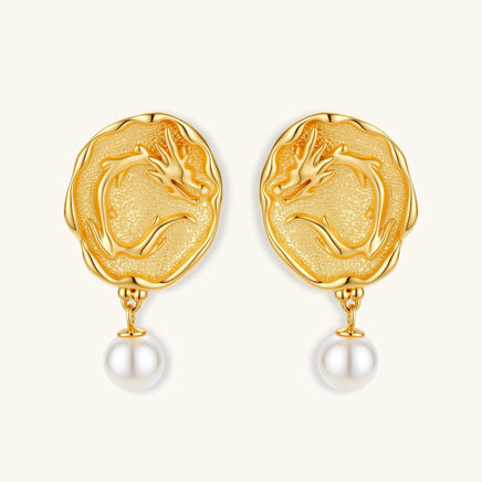 Ornate gold-plated dragon medallion earrings with white shell pearl drops on beige background, featuring detailed Chinese motifs.