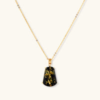 18k gold-plated necklace and earrings with green amber pendants featuring golden inclusions on cream background