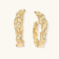 Gold-tone sculptural hoop earrings with irregular molten texture and organic curved edges | Olaty
