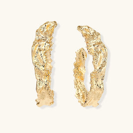 Gold-tone sculptural hoop earrings with irregular molten texture and organic curved edges | Olaty