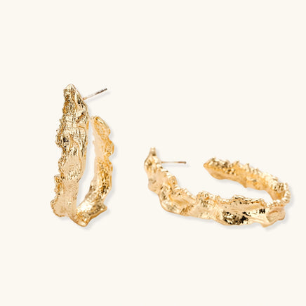 Side angle of gold-tone textured hoop earrings showing open hoop shape and post fittings | Olaty