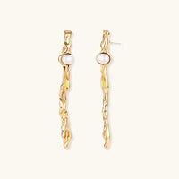 Long gold-tone sculptural drop earrings with flowing organic texture and round white pearl accents | Olaty