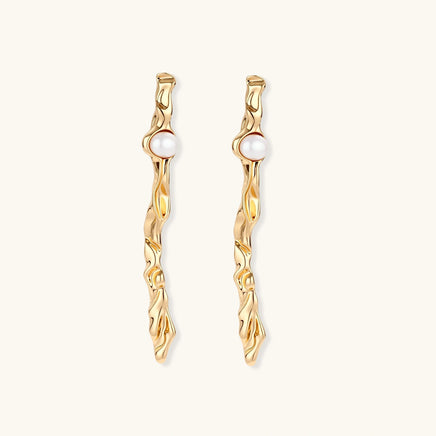 Front view of long gold-tone pearl drop earrings with sculptural twisted wave design | Olaty