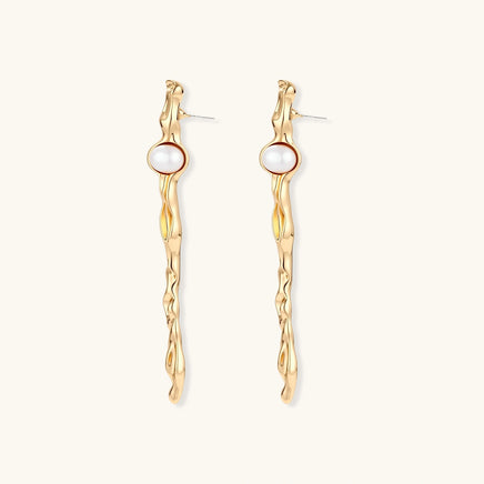 Gold-tone flowing statement earrings with round white pearls and visible post fittings | Olaty