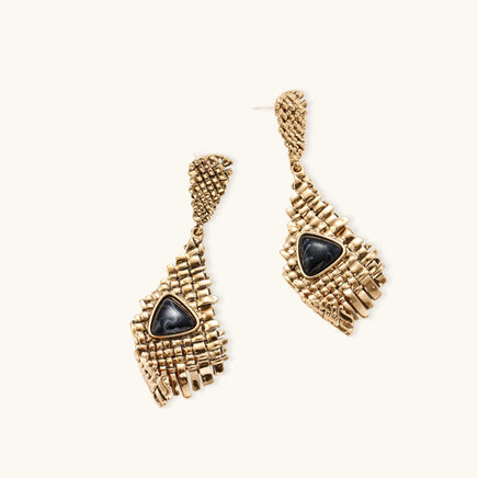 Angled view of architectural gold-tone drop earrings with woven grid texture and black resin accents | Olaty