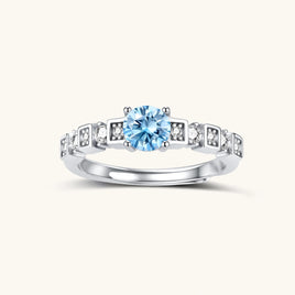Geometric sterling silver ring with light blue moissanite center stone and square diamond accents on white background
