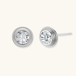 Close-up of sterling silver stud earrings featuring concentric circular frames with brilliant moissanite centers