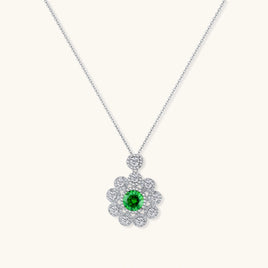 Delicate sterling silver necklace with flower-shaped pendant featuring bright green center moissanite and clear accent stones