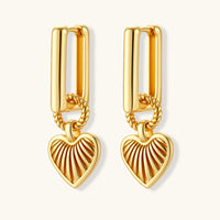 Gold-plated huggie earrings with textured heart charms featuring radiating sunburst patterns on white background.