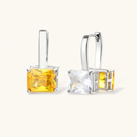 Close-up of drop hoop earrings with clear and golden yellow square zirconia stones | Olaty