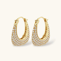 Gold-plated hoop earrings fully covered in sparkling zircon crystals with hinged closure on neutral background