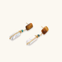 Amber and baroque pearl drop earrings laid flat with turquoise accents and delicate gold chain details | Olaty