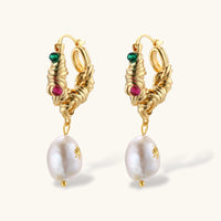 Angled view of textured gold hoop earrings with green and pink gems and pearl drops | Olaty