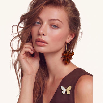Ethereal Mother of Pearl Butterfly Brooch worn on a brown dress with luminous white and detailed gold-tone wings | Olaty