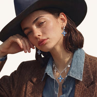 Model wearing blue denim cross charm necklace with silver-tone chain, zirconia and spike details | Olaty