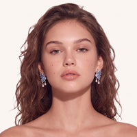 Model wearing blue denim butterfly drop earrings with sculptural silver-tone wings and zirconia drops | Olaty