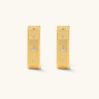 Front view of matching baroque ribbed gold huggie hoop earrings with delicate floral accents | Olaty