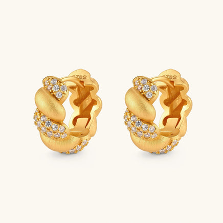 Angled pair of braided pavé huggie hoop earrings with brushed gold texture and sparkling cubic zirconia accents | Olaty