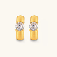 Front view of brushed solitaire huggie hoop earrings with prong-set round cubic zirconia stones | Olaty