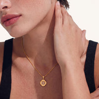 Model wearing Bloom gold petal medallion necklace with brushed floral pendant and sparkling cubic zirconia | Olaty