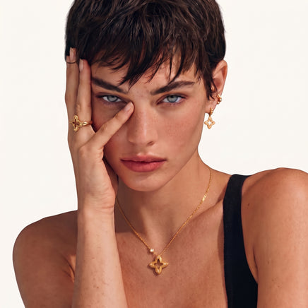 Model wearing Blooming Star gold open four-petal pendant necklace with delicate adjustable chain | Olaty